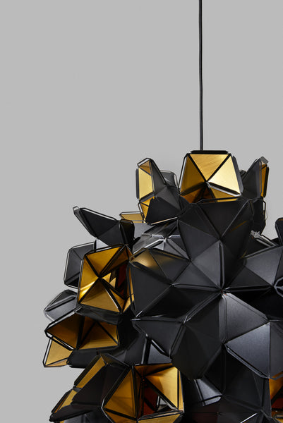 The Labyrinth Lamp is a light sculpture by Republiken. Hang it like a chandelier! The outside of the Labyrinth light sculpture has a matte black surface which contrast the protruding openings where the reflective inside is exposed.